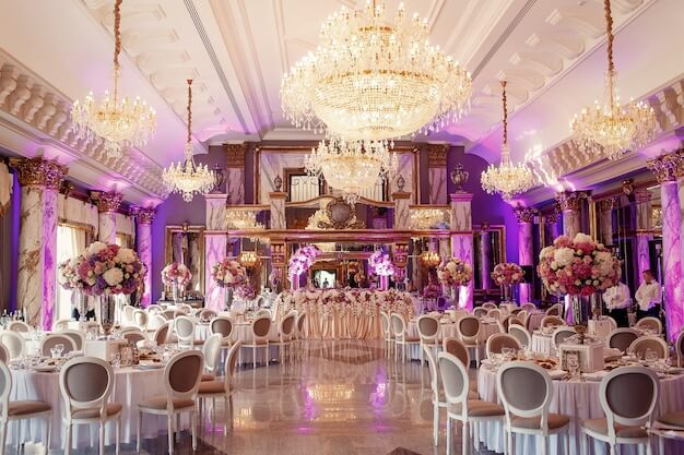 a room with tables and chairs and chandeliers